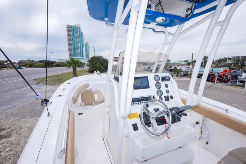 Slide: The Image of 2016 Key West 244 Center Console boat with modern dashboard and cityscape background. - 13