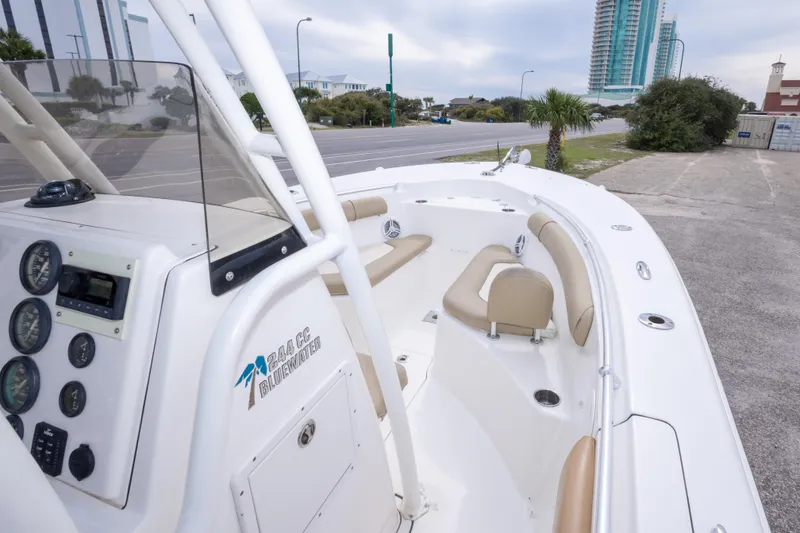 Slide: The Image of 2016 Key West 244 Center Console boat with beige seating, parked near a road. - 19