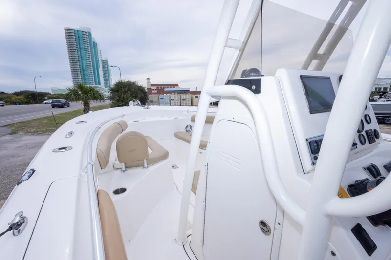 Slide: The Image of 2016 Key West 244 Center Console boat with modern dashboard, docked near a cityscape. - 20