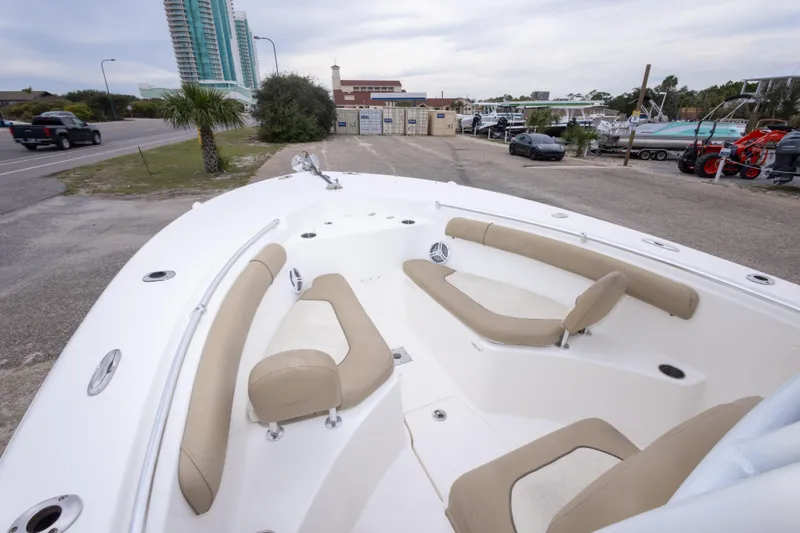 Slide: The Image of 2016 Key West 244 Center Console boat with beige seating, parked near a road. - 22