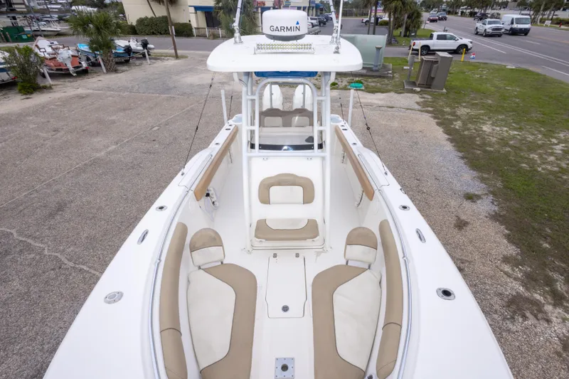 Slide: The Image of 2016 Key West 244 Center Console boat with beige seating, parked outdoors. - 23