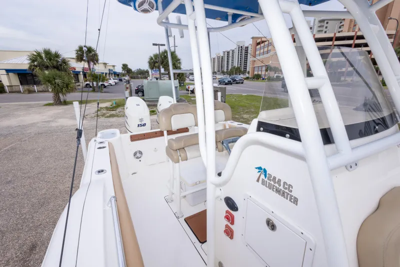 Slide: The Image of 2016 Key West 244 Center Console boat parked near a street with palm trees. - 25