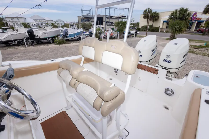 Slide: The Image of 2016 Key West 244 Center Console boat with dual Suzuki 150 engines, docked outdoors. - 29