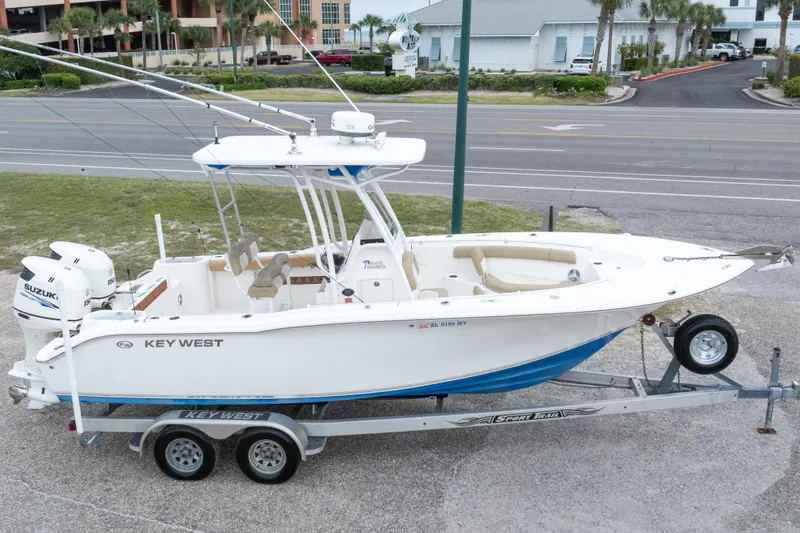 Slide: The Image of 2016 Key West 244 Center Console boat on trailer, parked near a road. - 31