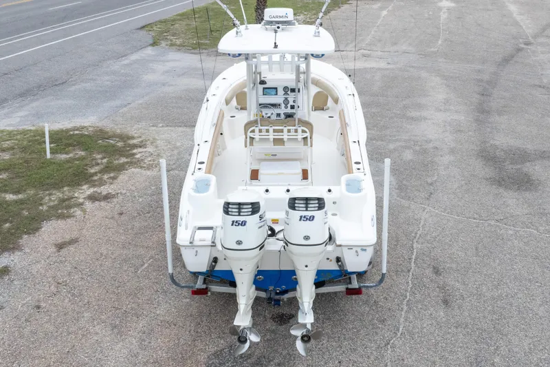 Slide: The Image of 2016 Key West 244 Center Console boat with dual outboard engines, parked on pavement. - 33