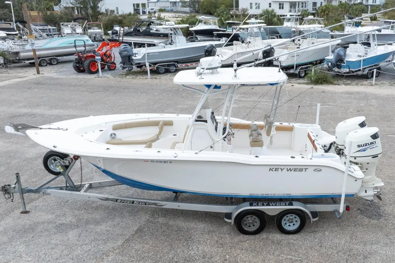 Slide: The Image of 2016 Key West 244 Center Console boat on trailer, parked in a marina with other boats. - 35