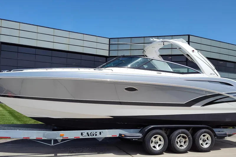 The Image of 2017 Formula 310 Bowrider boat on trailer, sleek design, parked outdoors. - 1