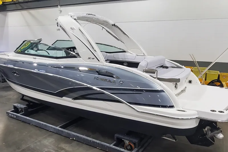 Slide: The Image of 2017 Formula 310 Bowrider boat in showroom, sleek design, white and blue exterior. - 3