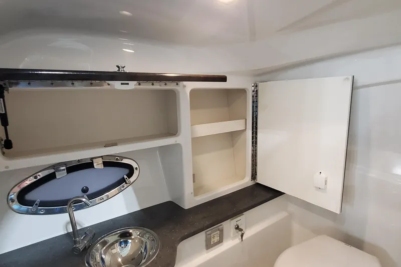 Slide: The Image of 2017 Formula 310 Bowrider interior with sink, storage cabinets, and porthole window. - 37