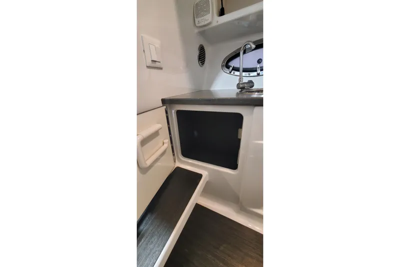 Slide: The Image of Interior of 2017 Formula 310 Bowrider boat, featuring a compact sink and storage area. - 38