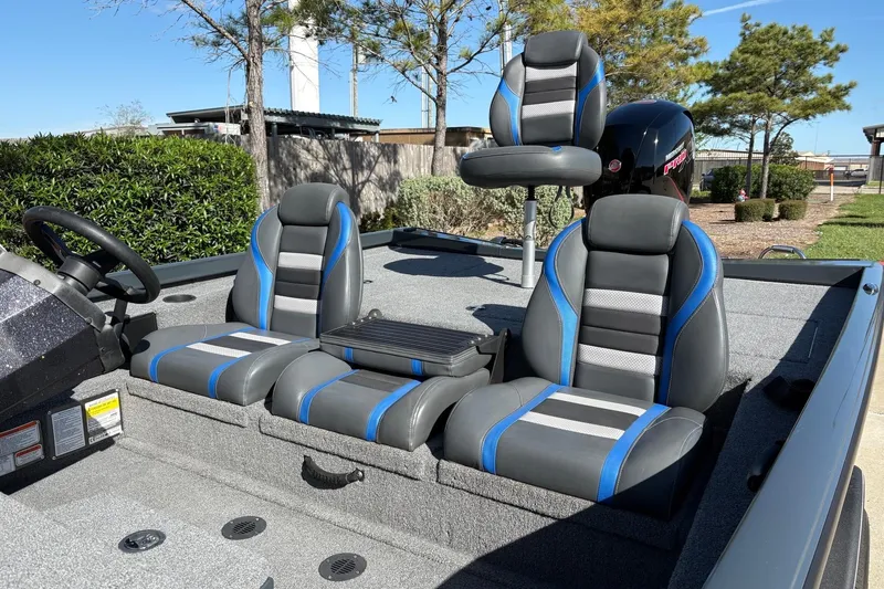 Slide: The Image of 2024 Ranger RT198P boat interior with gray and blue seating under clear skies. - 6