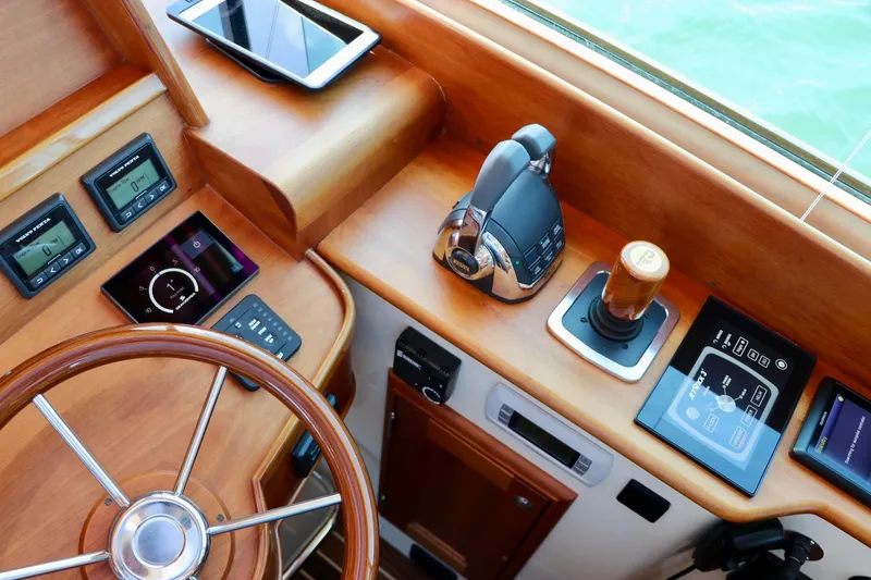 Slide: The Image of Helm of 2026 Hinckley Talaria 48 MKII with advanced navigation controls and wooden steering wheel. - 12