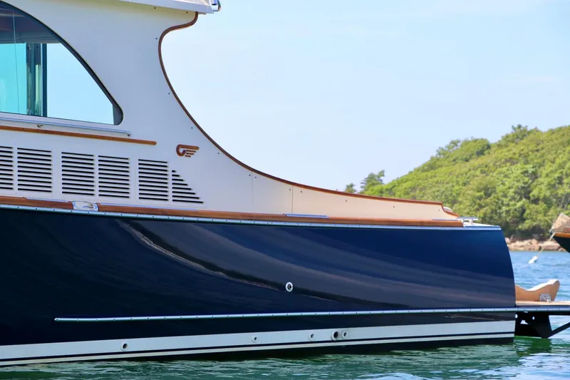 Slide: The Image of 2026 Hinckley Talaria 48 MKII yacht side view on water, showcasing sleek design. - 2