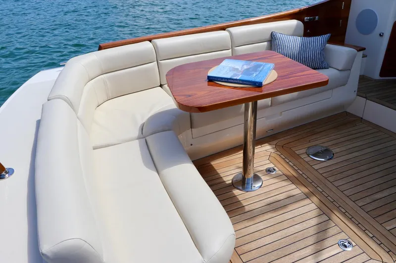 Slide: The Image of Luxurious seating area on 2026 Hinckley Talaria 48 MKII yacht with wooden table and cushion. - 6
