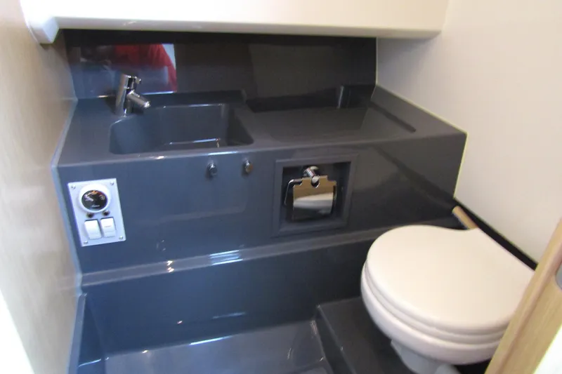Slide: The Image of 2023 Windy SR28 CC boat bathroom with sink, toilet, and control panel. - 18
