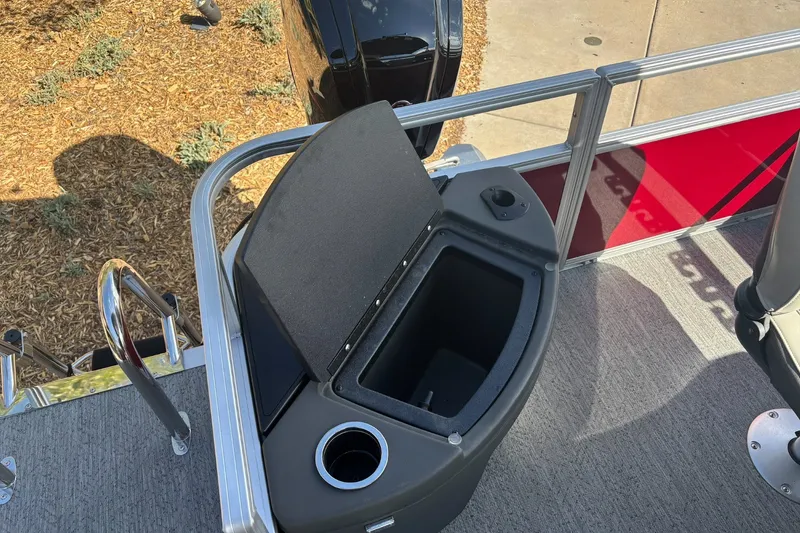 Slide: The Image of 2026 Sun Tracker Bass Buggy 18 DLX boat interior with storage compartment and cup holder. - 14