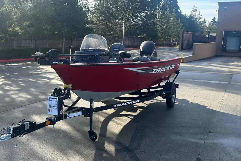 Slide: The Image of 2026 Tracker Pro Guide V-16 SC boat on trailer, red exterior, parked outdoors. - 2
