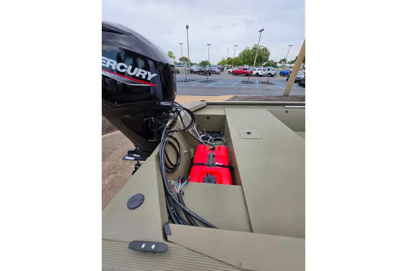 Slide: The Image of 2026 Tracker Grizzly 1648 SC boat with Mercury engine in parking lot. - 2
