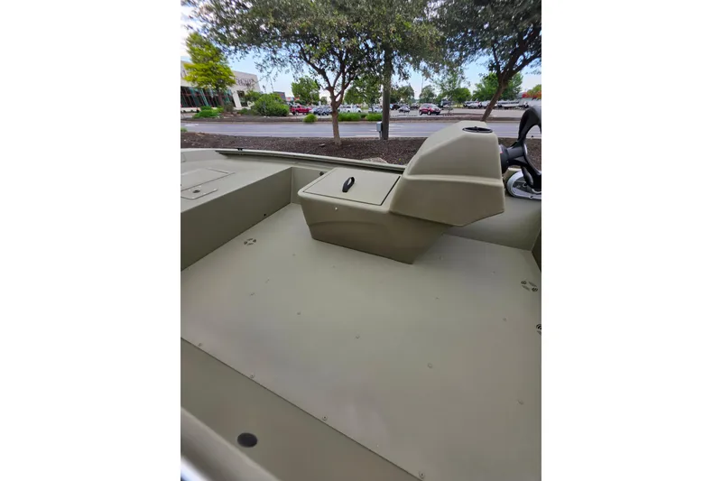 Slide: The Image of 2026 Tracker Grizzly 1648 SC boat interior with console, parked outdoors. - 5
