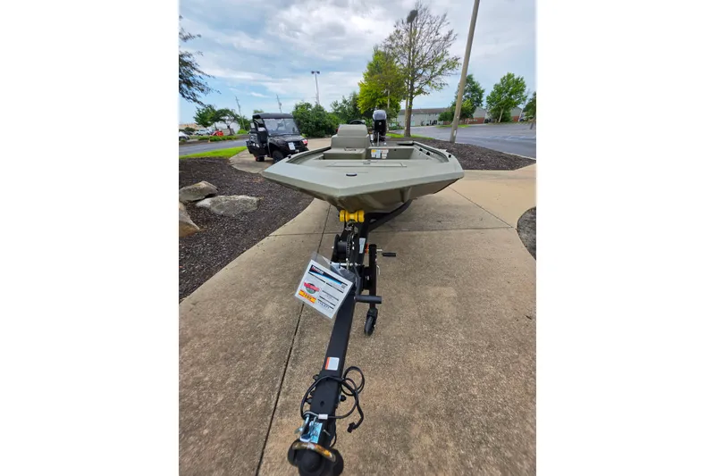 Slide: The Image of 2026 Tracker Grizzly 1648 SC boat on trailer, parked outdoors on a concrete path. - 6