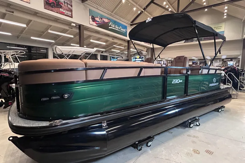 Slide: The Image of 2026 Regency 230 DL pontoon boat displayed indoors with green and black design. - 2