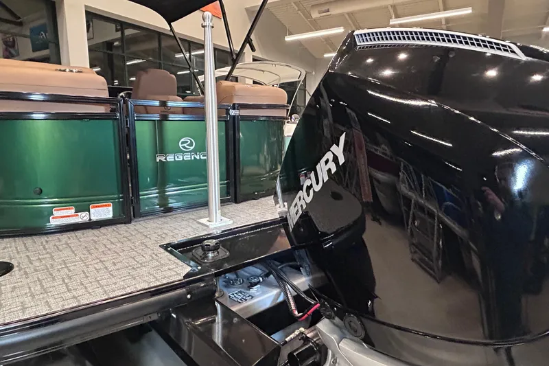 Slide: The Image of 2026 Regency 230 DL boat with Mercury engine, displayed indoors. - 9