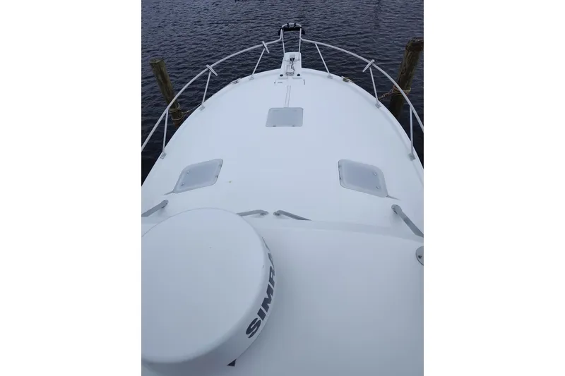 Slide: The Image of 1998 Luhrs 36 SX Open boat deck with railing, docked on calm water. - 10