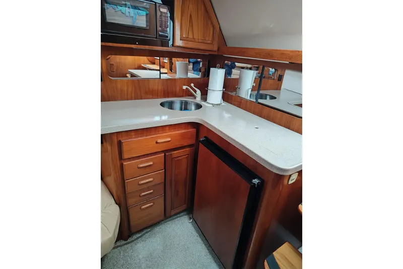 Slide: The Image of 1998 Luhrs 36 SX Open yacht kitchen with wood cabinetry and compact appliances. - 7