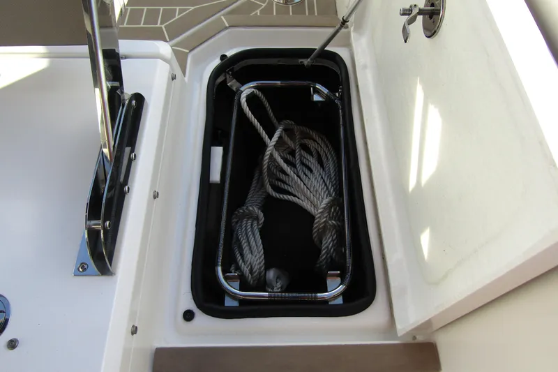Slide: The Image of Open storage compartment on 2023 Windy SR28 CC boat with coiled rope inside. - 22