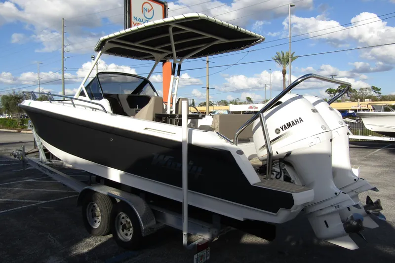 Slide: The Image of 2023 Windy SR28 CC boat on trailer with Yamaha engine, parked outdoors. - 1