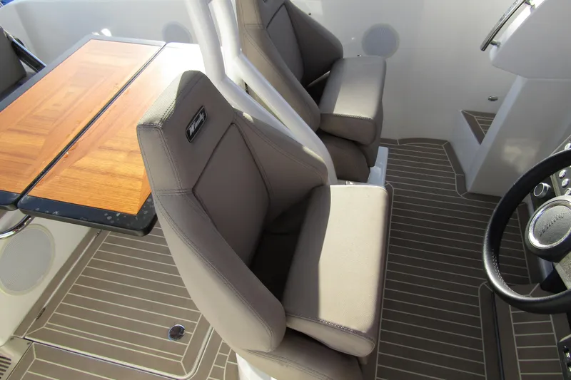 Slide: The Image of 2023 Windy SR28 CC boat interior with cushioned seats and wooden table. - 9