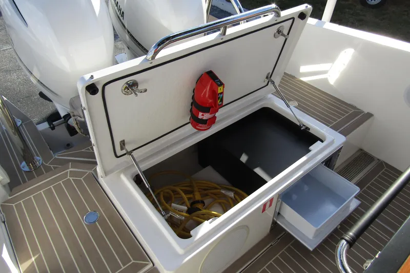 Slide: The Image of 2023 Windy SR28 CC boat storage compartment with fire extinguisher and equipment. - 20