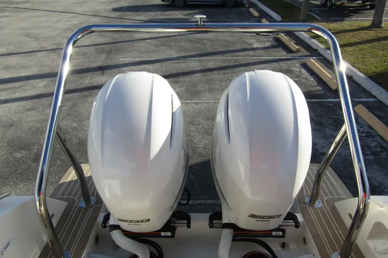 Slide: The Image of Twin outboard engines on 2023 Windy SR28 CC boat, parked on pavement. - 23