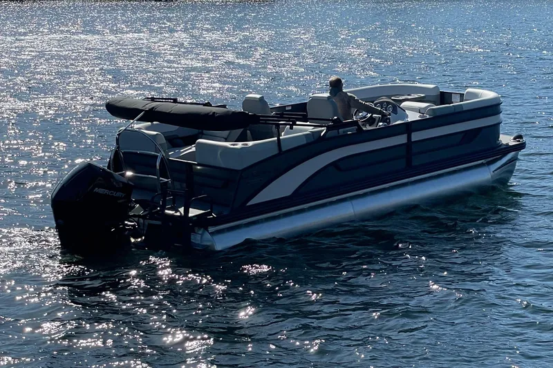 The Image of 2025 Lowe SS230WT pontoon boat cruising on a sunny lake. - 0