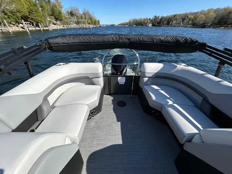 Slide: The Image of 2025 Lowe SS230WT pontoon boat interior with gray seating on a scenic lake. - 5