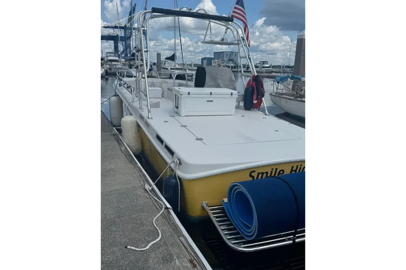 Slide: The Image of 2021 OceanPro 35 CWS boat docked, featuring a spacious deck and American flag. - 10