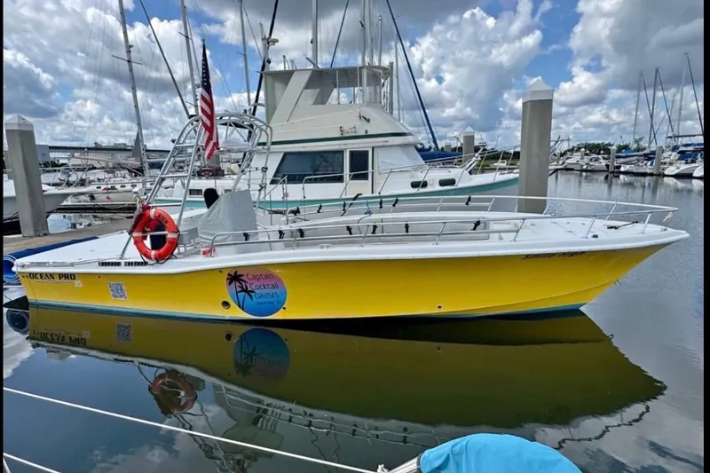 Slide: The Image of Yellow OceanPro 35 CWS boat docked in marina, 2021 model, with American flag and lifebuoy. - 8
