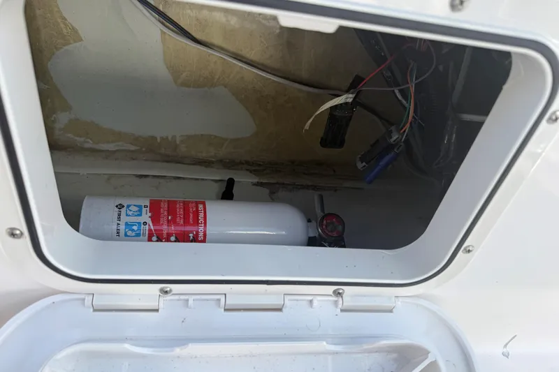Slide: The Image of Storage compartment of a 2007 Pro-Line 20 Sport boat with fire extinguisher and wiring. - 12