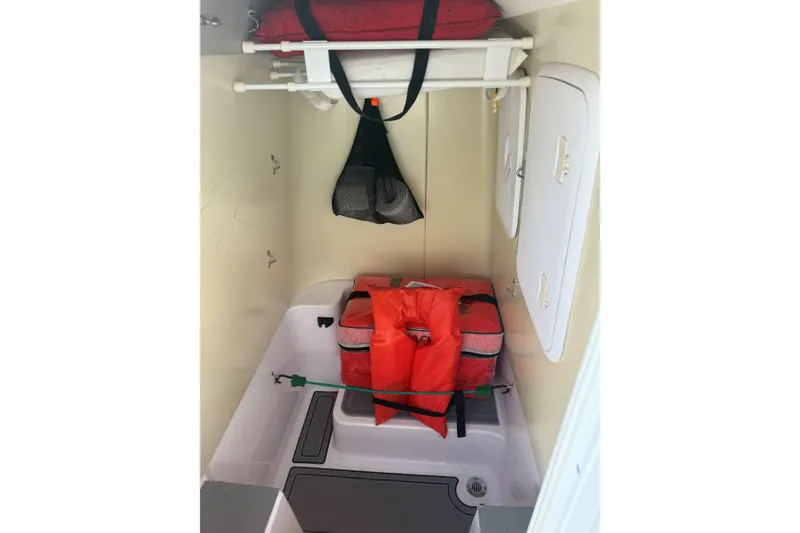 Slide: The Image of Storage compartment in a 2007 Pro-Line 20 Sport boat with life jackets and equipment. - 13