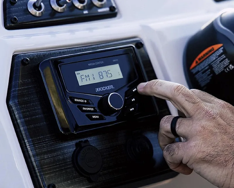 Slide: The Image of Hand adjusting Kicker media center on 2025 Lowe SS230WV boat dashboard. - 6