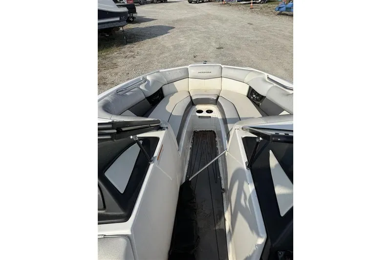 Slide: The Image of 2016 Moomba Craz boat interior with seating and cup holders, parked on gravel. - 6