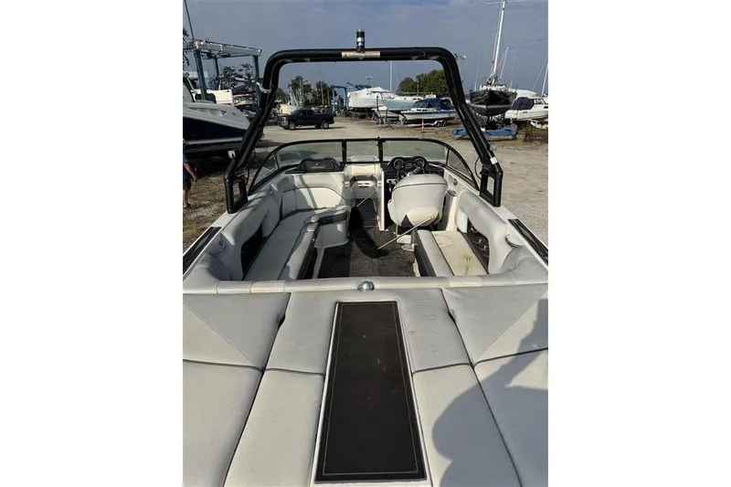 Slide: The Image of 2016 Moomba Craz boat interior with seating and steering wheel, docked outdoors. - 8