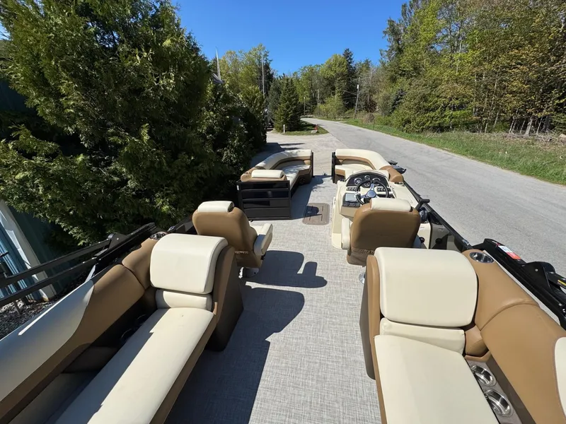 Slide: The Image of 2025 Lowe SS250WT pontoon boat with beige seating on a sunny day. - 6
