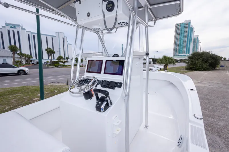 Slide: The Image of 2023 Dusky 252 Open Fisherman boat interior with modern controls and cityscape background. - 15