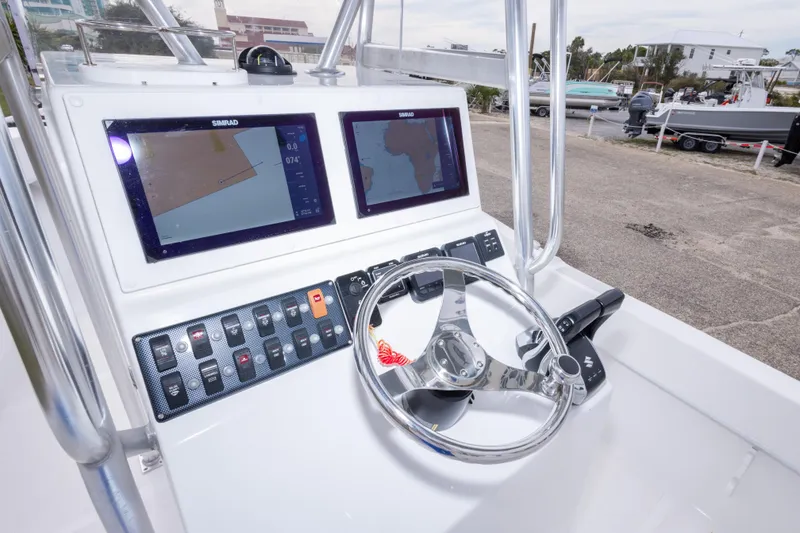 Slide: The Image of 2023 Dusky 252 Open Fisherman boat dashboard with dual Simrad displays and steering wheel. - 19
