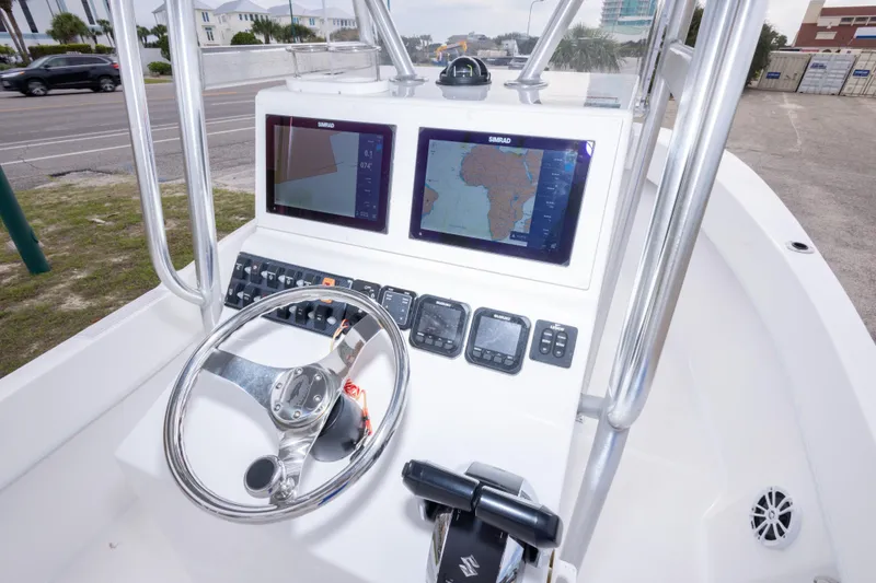 Slide: The Image of 2023 Dusky 252 Open Fisherman boat dashboard with navigation screens and steering wheel. - 20