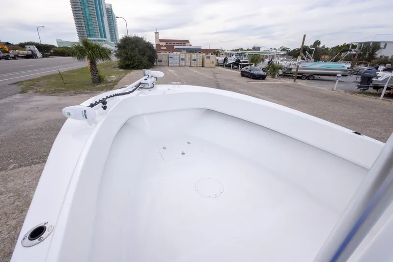 Slide: The Image of 2023 Dusky 252 Open Fisherman boat parked near a marina with modern buildings. - 22