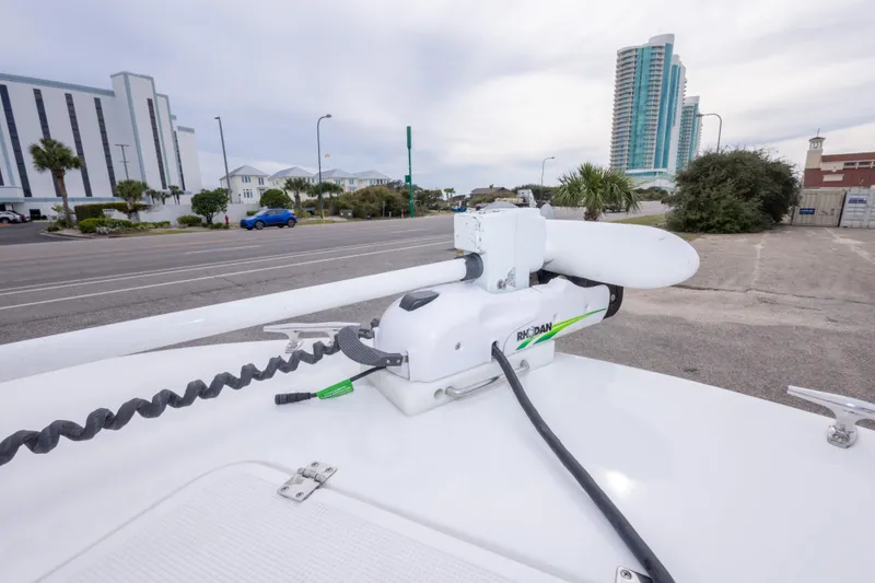 Slide: The Image of 2023 Dusky 252 Open Fisherman boat with Rhodan trolling motor in urban setting. - 25