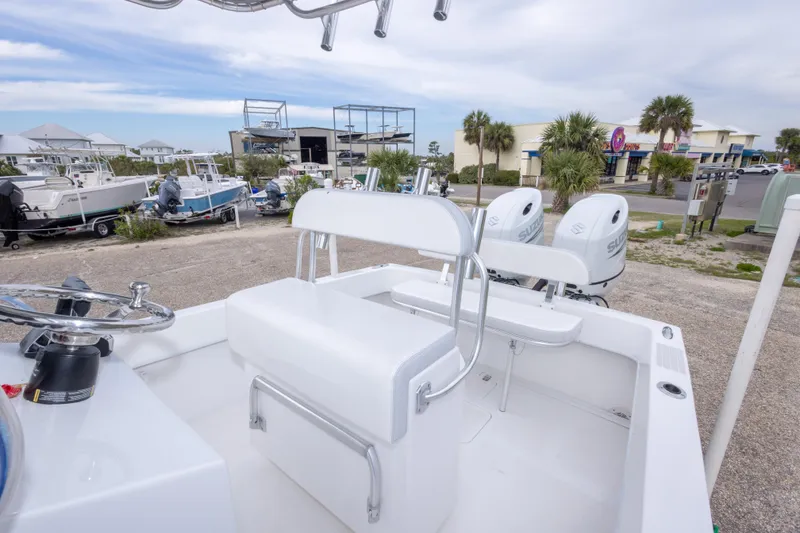 Slide: The Image of 2023 Dusky 252 Open Fisherman boat with dual outboard engines in a marina setting. - 28