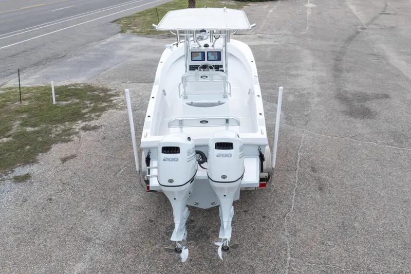 Slide: The Image of 2023 Dusky 252 Open Fisherman boat with dual outboard engines, parked on pavement. - 35